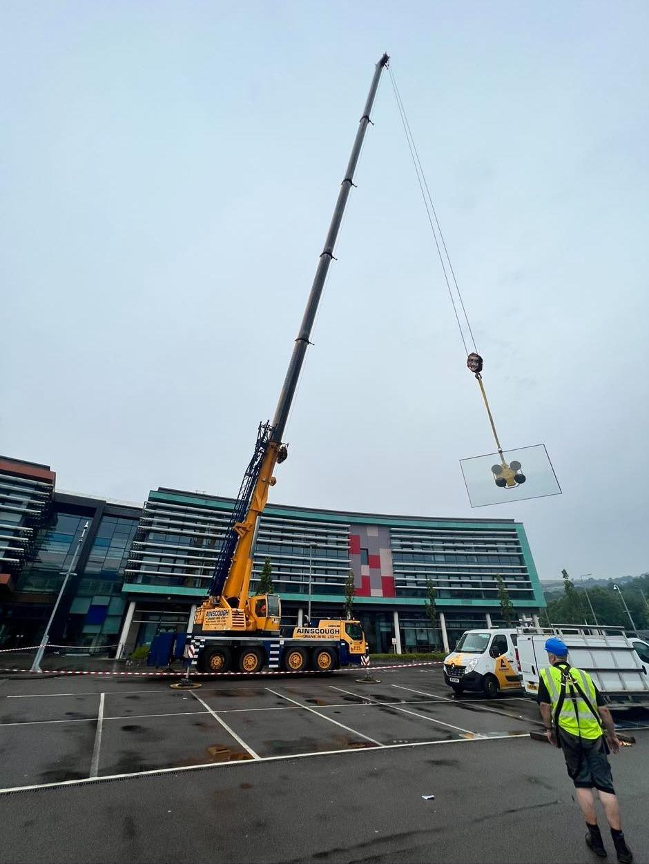 Commercial glazing lifted by crane, featured on the P&B Doors website